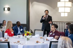 Brad Bettencourt speaking at an event in a suit